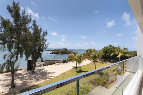a view of the beach from the balcony of a house at Ocean Grand Gaube by Host Agents in Grand Gaube