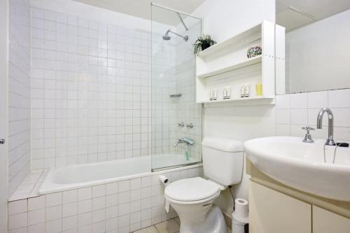 a white bathroom with a toilet and a sink at Gallop to Your Getaway! in Melbourne
