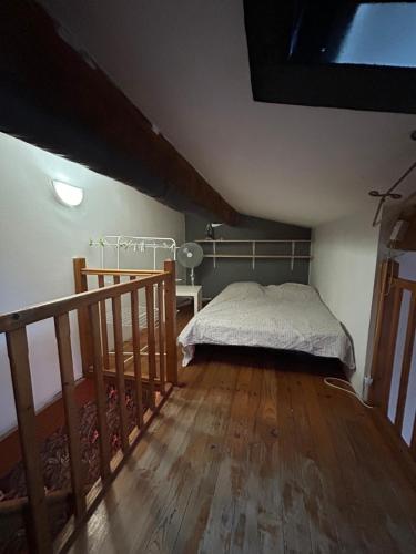 une chambre avec un lit et un parquet dans l'établissement Appartement en plein centre face à la mairie de Balaruc-les-Bains, à Balaruc-les-Bains