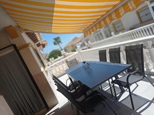 a blue table and chairs on a balcony with an umbrella at Casa Dulce Locura in Cabo Roig