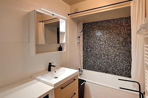 une salle de bain blanche avec un lavabo et une douche dans l'établissement Entre Lac et Montagne - Appt pour 4 - Garage privé, à Gérardmer