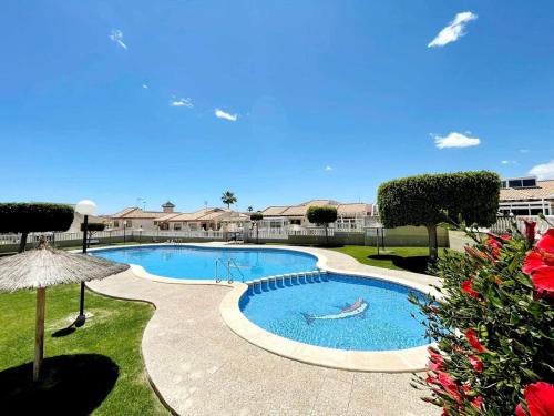 a swimming pool in a yard with an umbrella at Casa Dulce Locura in Cabo Roig