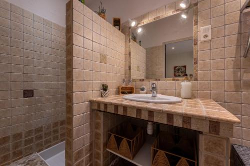 bagno con lavandino e specchio di Mas de Liam - Maison de plain-pied climatisée a Comps
