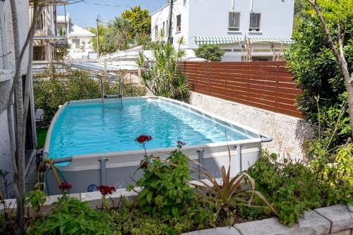 a swimming pool in a garden with a house at Stylish 4BR Villa - Herzliya Pituah in Herzelia 