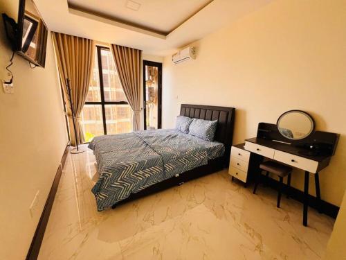 1 dormitorio con cama, escritorio y espejo en Relaxing Private Studio with Luxurious Pool and Gym By SYM B735 en Phnom Penh