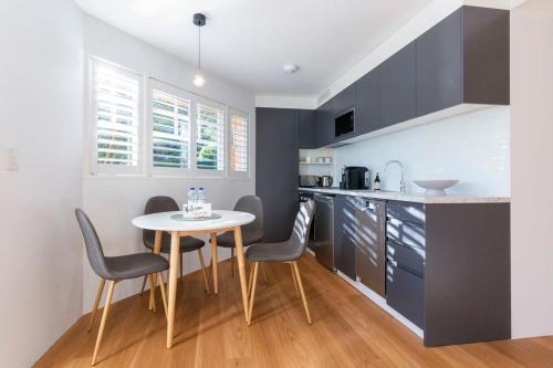 a kitchen with a table and chairs in a room at 2BDR Brand New Apt - Moments from RNSH & St Leonards in Sydney