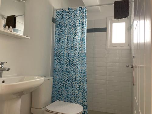 a bathroom with a shower with a blue shower curtain at Deda Apartments in Livadia