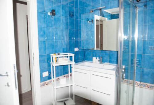 a blue tiled bathroom with a sink and a mirror at Casa Elia in Venice