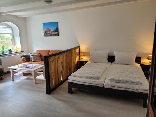 克魯姆赫爾恩的住宿－Gulfhof Anelis，一间卧室配有一张床和一张沙发