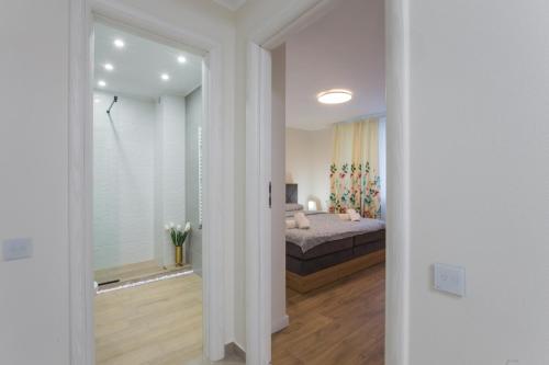 een witte slaapkamer met een bed en een raam bij Hermann Central Apartment in Sibiu