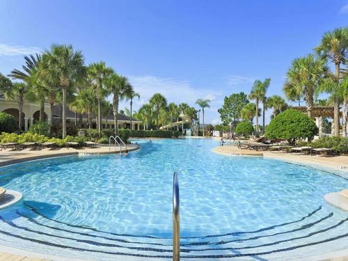 uma grande piscina num resort com palmeiras em Archfeld Villa 2582 em Orlando