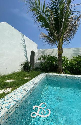 a swimming pool with a palm tree next to a palm tree at Lo Villa - Venuestay in Phu Yen