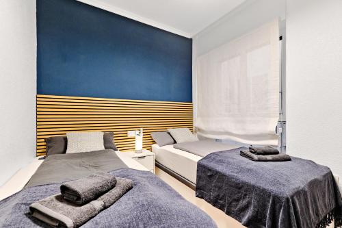 una camera da letto con due letti e una parete blu di Casa Encanto Torrevieja a Torrevieja