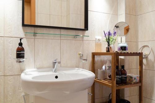 a bathroom with a white sink and a mirror at Feel Like Home @Strakova, Very central luxury APT in Bratislava