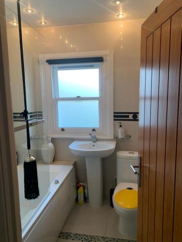 a bathroom with a sink and a window and a toilet at Superbly Furnished Apartment in Central London in London