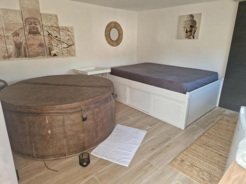 Cette chambre comprend un lit et un grand tonneau. dans l'établissement Spa Brunoy, à Brunoy