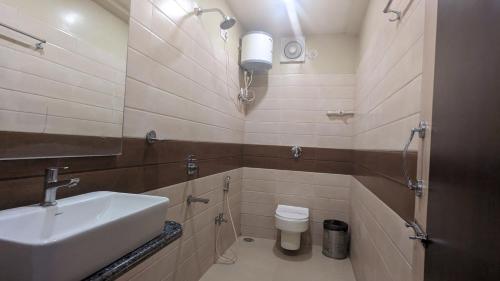 uma casa de banho com um lavatório e um WC em Hotel Binapani em Tarapith