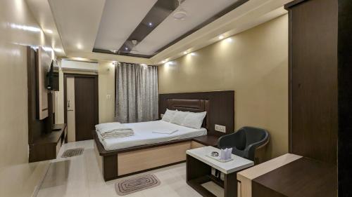 um pequeno quarto com uma cama e uma cadeira em Hotel Binapani em Tarapith