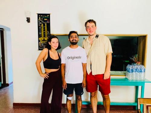 a group of three people standing in a room at Ceylon Glory Hostel in Negombo