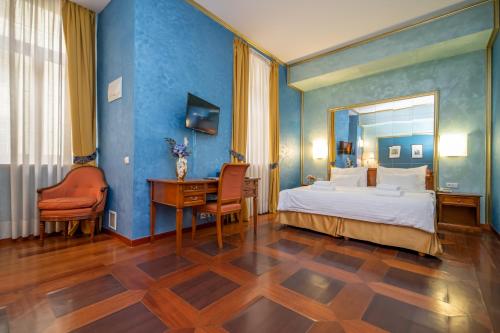 a bedroom with a bed and a desk and a mirror at Hotel Kinsky Fountain in Prague