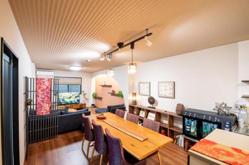 a living room with a wooden table and chairs at NARANOYA in Nara
