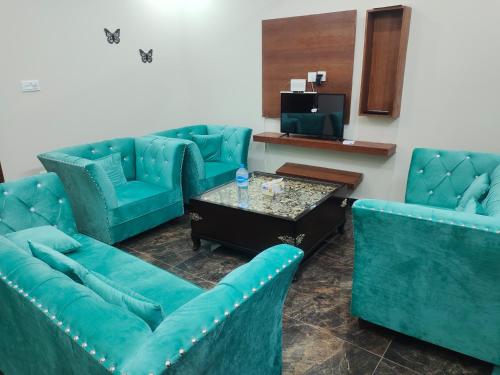 una sala de espera con sofás azules y una mesa en Airwaylodges en Islamabad