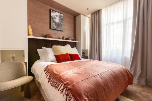 a bedroom with a bed with red pillows and a window at Luxueux Logement Grand Place et Opéra clim by Lity in Lille