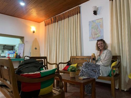 a woman sitting on a chair in a living room at Ceylon Glory Hostel in Negombo