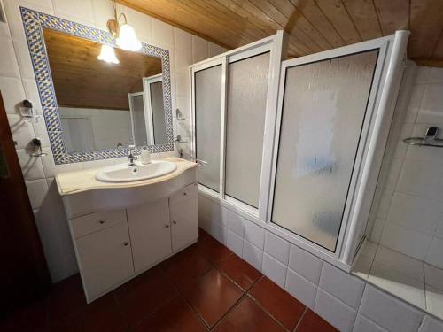 La salle de bains est pourvue d'un lavabo, d'une douche et d'un miroir. dans l'établissement Casa dos Avós no Grande Lago, à Granja