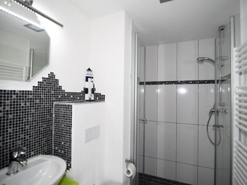 y baño blanco con lavabo y ducha. en Ferienwohnung am Haff, en Grambin