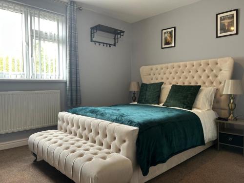 Luxe 5 Bed Bungalow In Snodland, Medway, Kent في Kent: غرفة نوم مع سرير أبيض كبير مع اللوح الأمامي المحبط