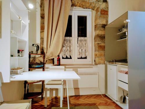 una cucina con tavolo bianco e finestra di Isola Studio Rosa a Izola