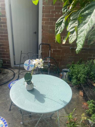 un tavolo con un vaso con una pianta sopra di Hilda Grange a Sydney