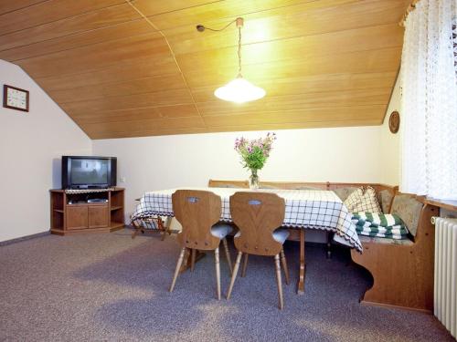 ein Esszimmer mit einem Tisch und Stühlen sowie einem TV in der Unterkunft Modern Apartment in Bad Peterstal Griesbach with Vineyards in Bad Peterstal
