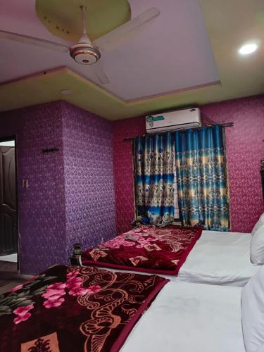 a bedroom with a bed and a purple wall at City Palace Hotel in Lahore