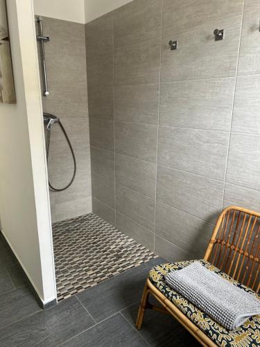 eine Dusche mit einer Bank und einem Stuhl im Bad in der Unterkunft Très belle villa avec piscine chauffée CASALEONI in Prunelli-di-Fiumorbo