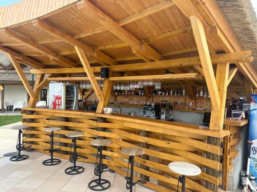 un bar en bois avec des tabourets devant lui dans l'établissement Complex Andris, à Murighiol