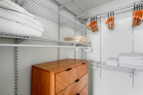 a walk in closet with white shelves and a wooden cabinet at Blueground Downtown pool lounge gym nr shops ATX-257 in Austin