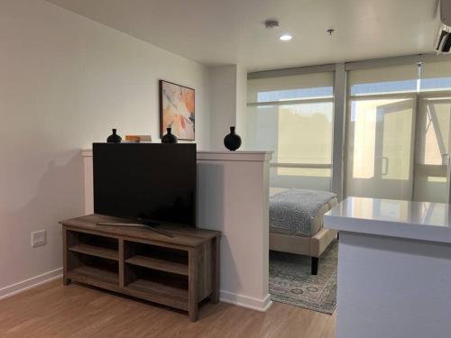 a living room with a flat screen tv and a bed at Fortuna-Seaside Retreat in Santa Monica, steps to the beach, free parking in Los Angeles