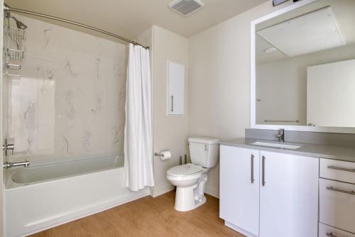 a bathroom with a toilet and a tub and a sink at Blueground Oakland gym ac near restaurants SFO-1684 in Oakland