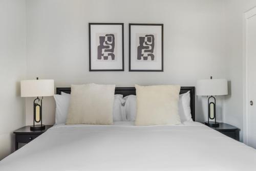 una camera da letto con un grande letto bianco con due lampade di Blueground Oakland roof lounge near dining SFO-1718 a Oakland