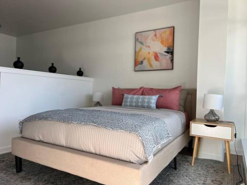 um quarto com uma cama grande e almofadas cor-de-rosa em Seaside Retreat in Santa Monica, steps to the beach, free parking em Los Angeles
