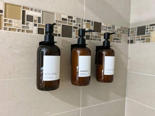 three bottles of soap on a wall in a bathroom at Seaside Retreat in Santa Monica, steps to the beach, free parking in Los Angeles