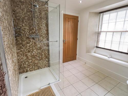 bagno con doccia e porta in vetro di Argyle Cottage ad Ambleside