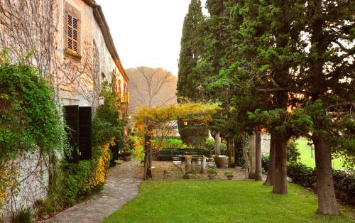 a garden with trees and a building and a yard at Fangar Agroturismo in Campanet