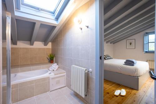 a bathroom with a tub and a bed in a room at Casona Las Cinco Calderas in Galizano