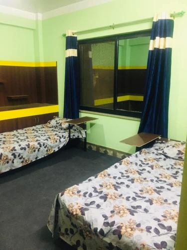 een kamer met 2 bedden en een raam erin bij Om Kedareshwar Boys Hostel in Kathmandu