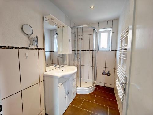 a white bathroom with a sink and a shower at Monteurhaus in Heidenheim in Heidenheim an der Brenz