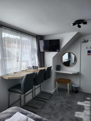 a room with a table and chairs and a mirror at St Georges Guest House in St Peter Port