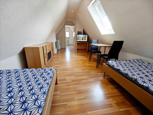 a room with two beds and a table and a kitchen at Monteurhaus in Heidenheim in Heidenheim an der Brenz